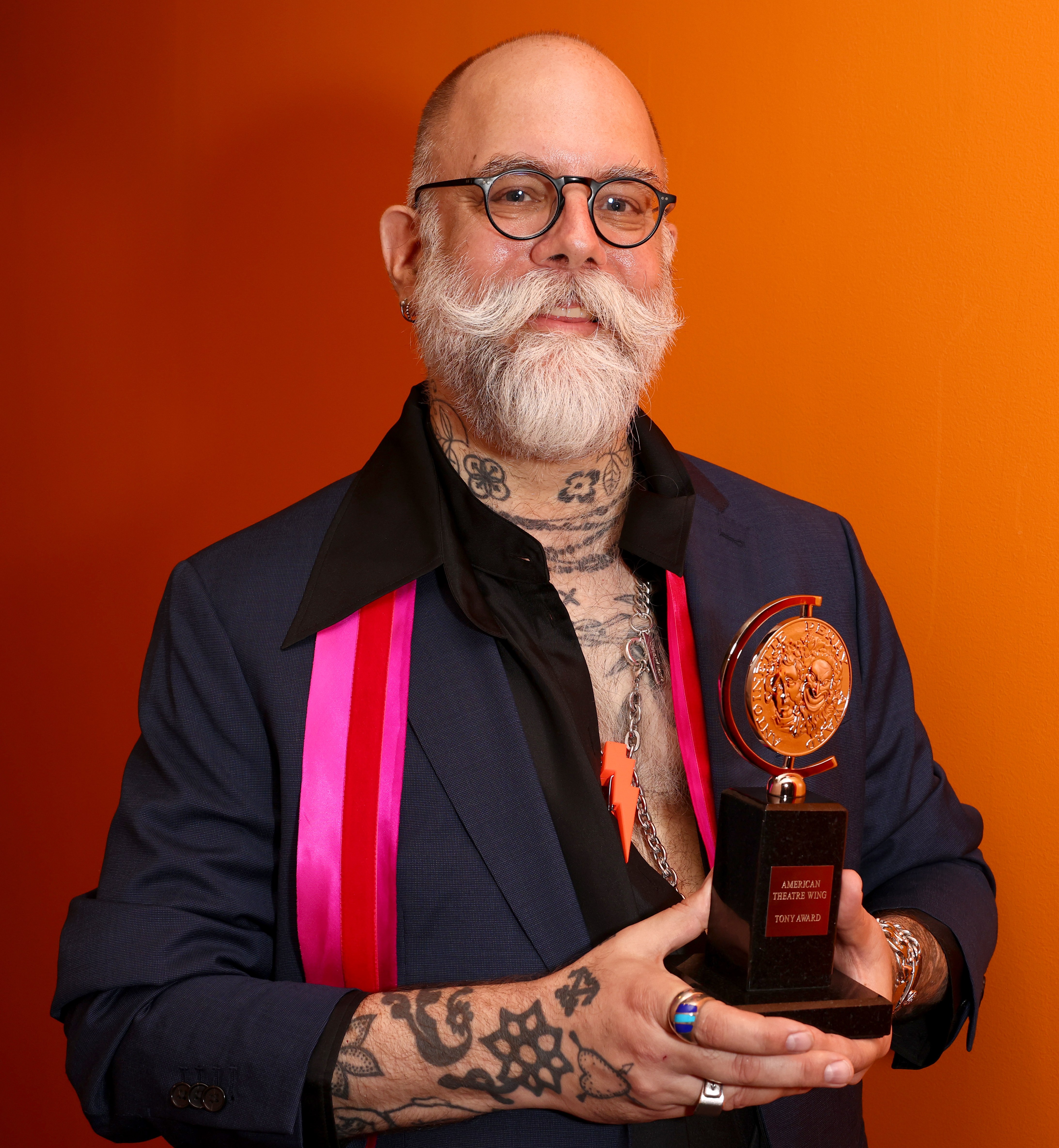 David Zinn holding his Tony Award for Best Scenic Design of a Play.