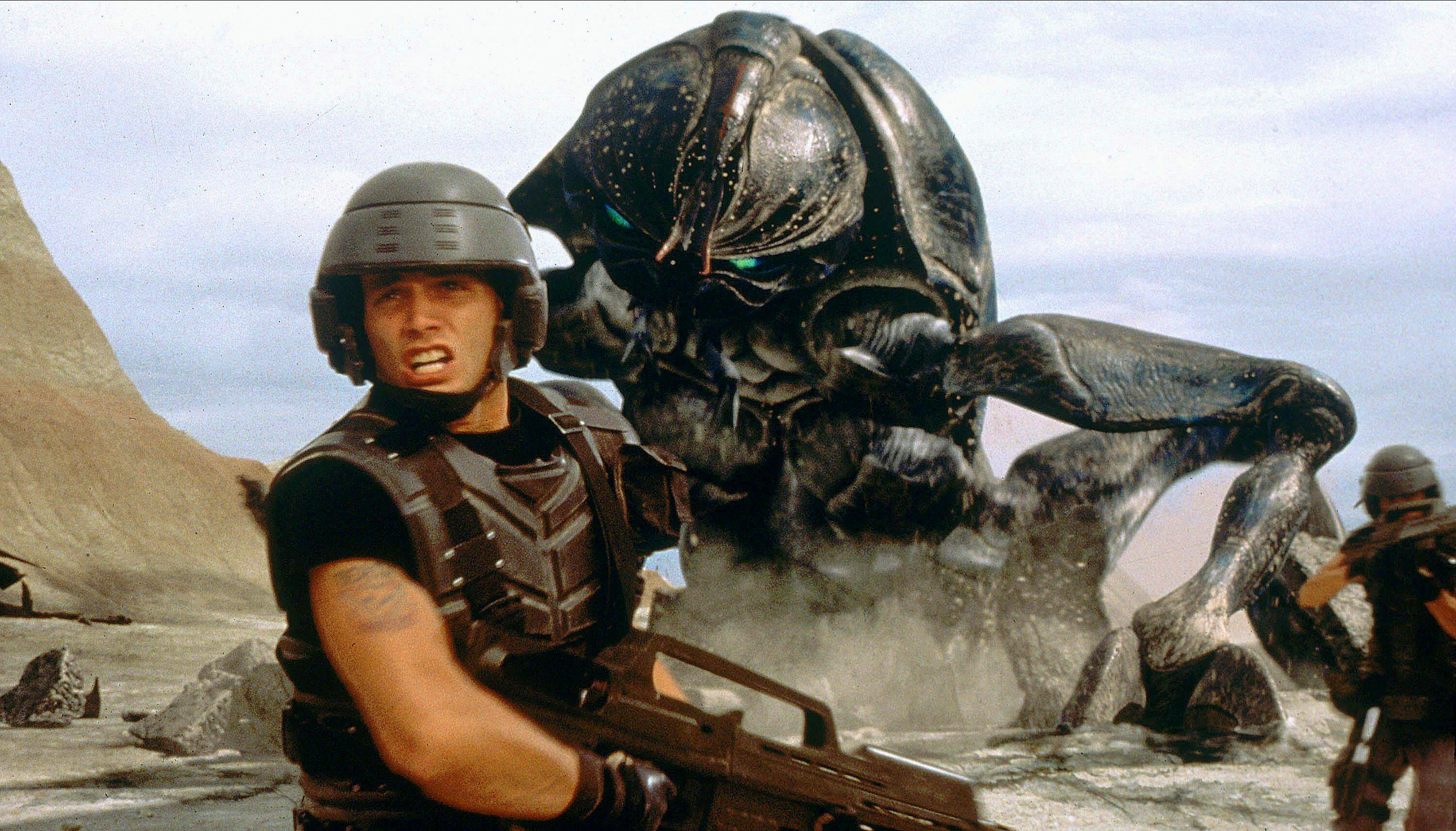 Casper Van Dien in Starship Troopers facing off with a giant bug.
